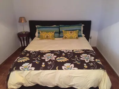 a bedroom with a large bed with a blanket and pillows at Villa Thermopilon in Larnaka