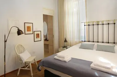 a bedroom with a large bed and a chair at Centrum Hotel - City Center in Nicosia