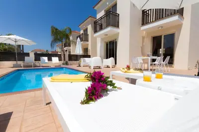 a villa with a swimming pool and a white table at Casa Di Kappari in Protaras