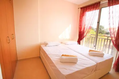 a bedroom with a bed with white sheets and a window at Casa Di Kappari in Protaras