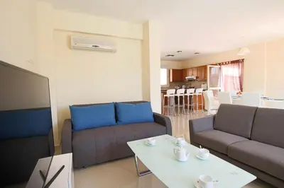 a living room with two couches and a table at Casa Di Kappari in Protaras