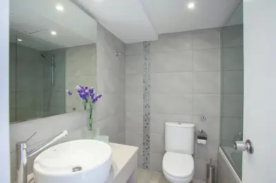 a bathroom with a white toilet and a sink at Limanaki Beach Hotel & Suites in Ayia Napa