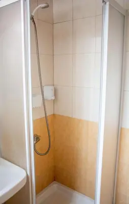 a shower with a shower head in a bathroom at Marina's Rooms in Larnaka