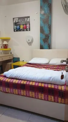 a bedroom with a bed with a colorful blanket on it at Marina's Rooms in Larnaka