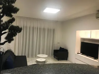 a living room with a television and a couch and chair at Olosuites in Limassol