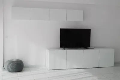 a flat screen tv sitting on top of a white cabinet at Olosuites in Limassol