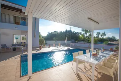 a patio with a table and chairs next to a pool at Villa Orka in Protaras