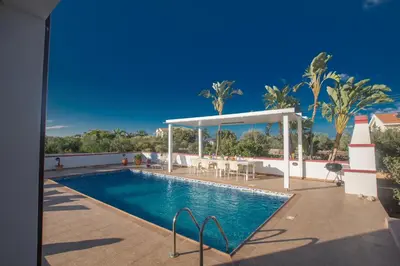 a swimming pool with a gazebo next to a resort at Villa Orka in Protaras