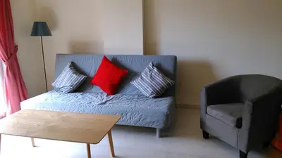 a living room with a blue couch and a chair at Modern City Center Apt in Larnaka