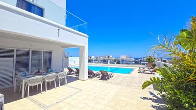 a patio with a table and chairs and a swimming pool at Villa Jenny in Protaras