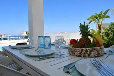 a table with a bowl of fruit and glasses on a balcony at Villa Jenny in Protaras