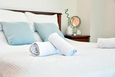 two rolls of towels on a white bed at Villa Jenny in Protaras