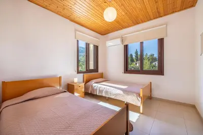 two beds in a room with two windows at The River House in Trimiklini
