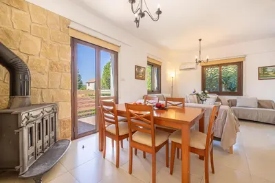a living room with a table and a fireplace at The River House in Trimiklini