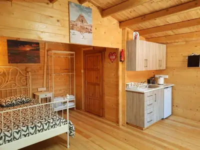 a kitchen in a log cabin with a bed and a sink at Cyprus Glamping Park in Ayios Theodhoros