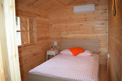 a bedroom with a bed in a wooden cabin at Cyprus Glamping Park in Ayios Theodhoros