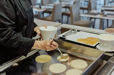 a man is preparing food in a kitchen at Tasia Maris Sands (Adults Only) in Ayia Napa