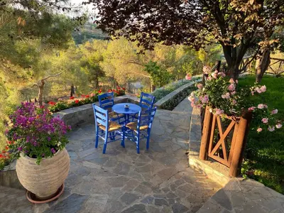 a patio with a table and chairs and flowers at Anti Onirou in Flasou