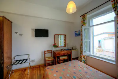 a bedroom with a bed and a desk and a window at Alkisti City Hotel in Larnaka