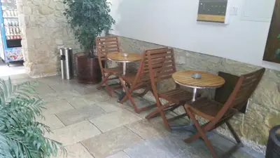 a group of wooden chairs and tables in a room at Alkisti City Hotel in Larnaka