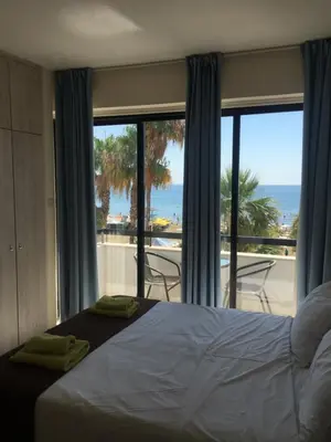 a bedroom with a bed and a view of the ocean at Alex Beach Apartment 203 in Larnaka