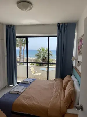 a bedroom with a bed and a view of the ocean at Alex Beach Apartment 203 in Larnaka