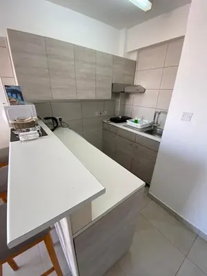 a kitchen with a white counter and a white refrigerator at Alex Beach Apartment 203 in Larnaka
