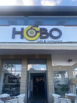 a building with a sign for a cafe and restaurant at Alex Beach Apartment 203 in Larnaka