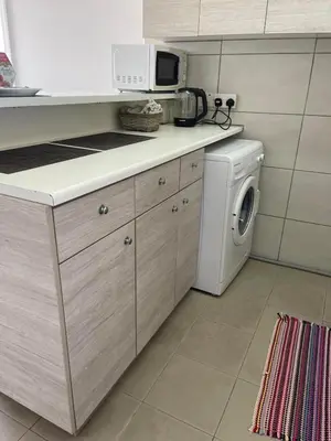 a kitchen with a washing machine and a microwave at Alex Beach Apartment 203 in Larnaka