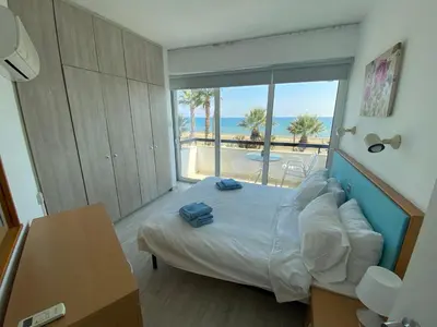 a bedroom with a bed with a view of the ocean at Alex Beach Apartment 203 in Larnaka