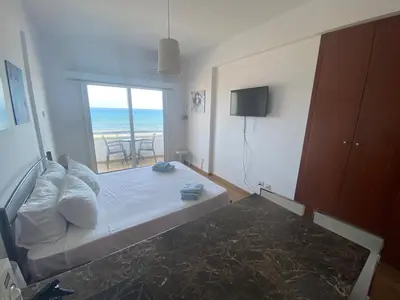 a bedroom with a bed with a view of the ocean at Alex Beach Apartment 33 in Larnaka