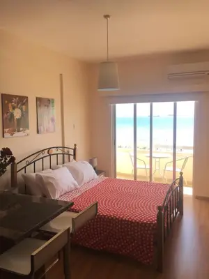 a bedroom with a bed and a view of the ocean at Alex Beach Apartment 33 in Larnaka