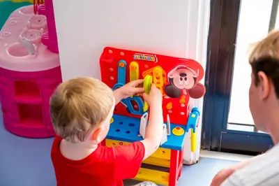 a young boy playing with a toy with a man at Christofinia Hotel in Ayia Napa