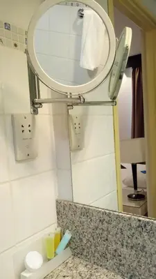 a bathroom with a mirror and a sink at Castelli Hotel Nicosia in Nicosia