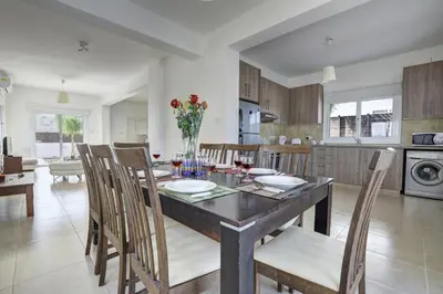 a kitchen and dining room with a table and chairs at Nissi Villa Gintare in Ayia Napa