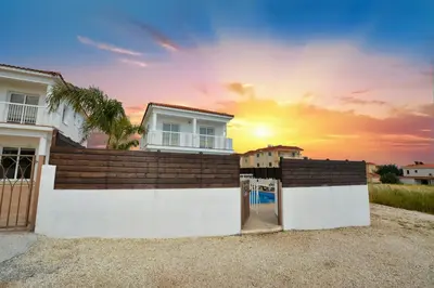 a house with the sunset in the background at Nissi Villa Christa in Ayia Napa