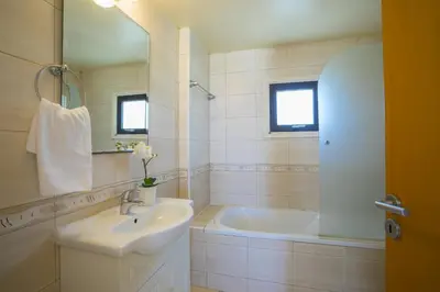 a white bathroom with a sink and a tub at Villa Mylos 7 in Protaras