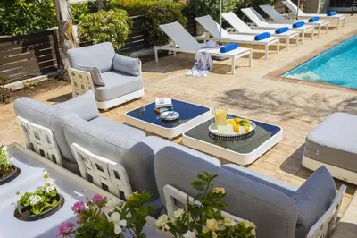 an outdoor patio with lounge chairs and a pool at Villa Mylos 7 in Protaras