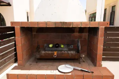 a brick wall with a grill with apples on it at Villa Mylos 7 in Protaras