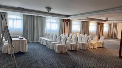 a room with rows of white chairs and a stage at Navarria Blue Hotel in Limassol