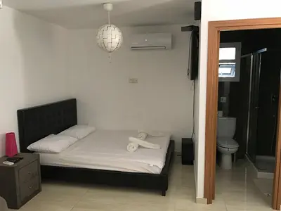 a small bedroom with a bed with a black headboard at Luxury Studio Ayia Napa Center in Ayia Napa