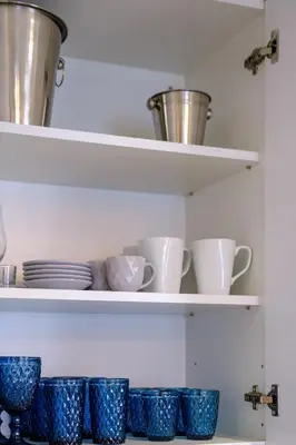 a row of blue cups and plates on shelves at Lazuli Sea View Beachfront Ap 254 in Larnaka
