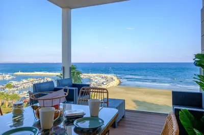 a view of the beach from a patio with a table and chairs at Lazuli Sea View Beachfront Ap 254 in Larnaka