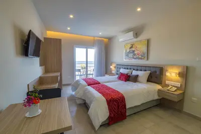 a bedroom with a large bed and a television at Zodiac Hotel Apartments in Larnaka