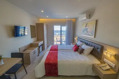 a bedroom with a large bed and a desk at Zodiac Hotel Apartments in Larnaka
