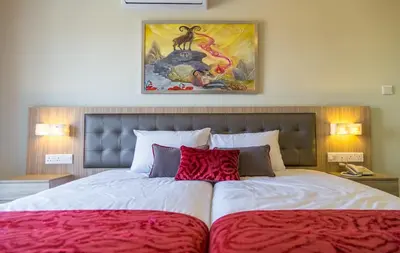 a bedroom with a large bed with red pillows at Zodiac Hotel Apartments in Larnaka