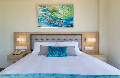 a bedroom with a bed and a painting on the wall at Zodiac Hotel Apartments in Larnaka