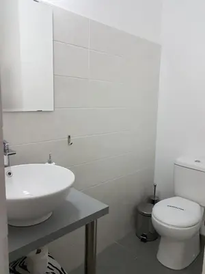 a white bathroom with a sink and a toilet at Julia's Residence in Nicosia