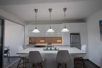 a kitchen with a white table and chairs at Poseidon Apartment by Michalis in Ayia Napa