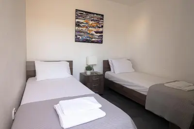 two beds in a room with white sheets at Poseidon Apartment by Michalis in Ayia Napa
